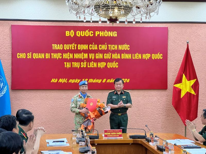 Thượng tướng Hoàng Xuân Chiến trao Quyết định của Chủ tịch nước và tặng hoa chúc mừng Thượng tá Trương Anh Tuấn đi thực hiện nhiệm vụ tại Trụ sở Liên hợp quốc.