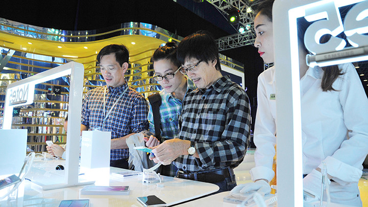 Khách hàng trải nghiệm sản phẩm điện thoại di động mới. Ảnh: NGUYỆT ANH