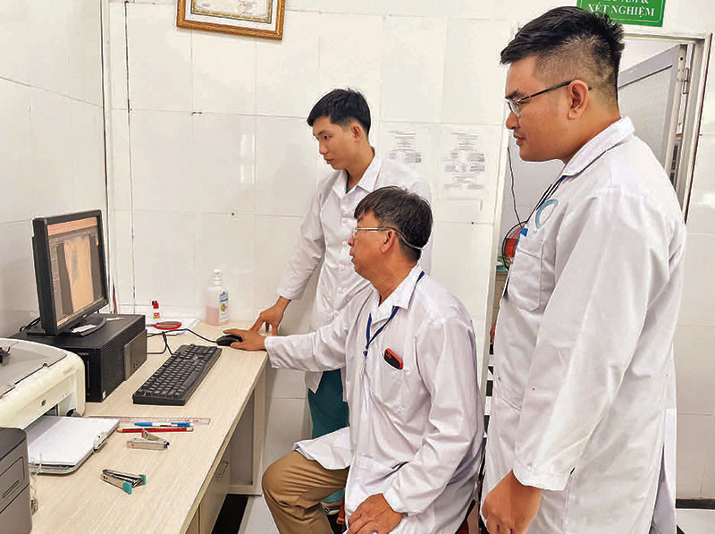 Các bác sĩ Trạm Y tế xã Thạnh An chẩn đoán tình trạng bệnh từ hình ảnh trên máy tính.