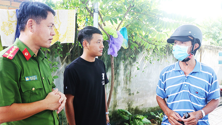 Anh Đẳng (áo đen) cùng Đại úy Đậu Xuân Cửu đi tuyên truyền, phổ biến pháp luật trên địa bàn thị trấn Tân Khai.