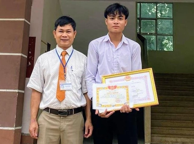 Đại diện Ban giám hiệu Trường Trung học phổ thông Nguyễn Du trao giấy khen cho em Kpắ Y Sem.