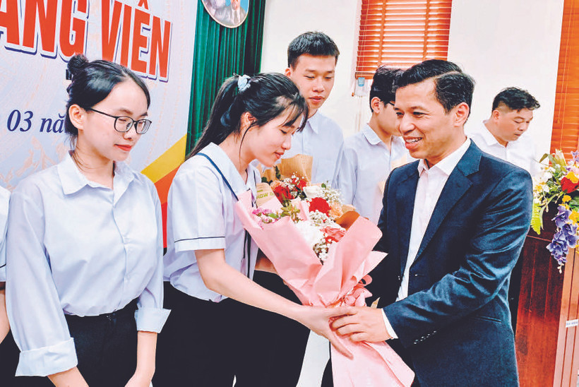 Phó Trưởng ban Tổ chức Thành ủy Hải Phòng Nguyễn Hồng Vinh tặng hoa các đảng viên mới là học sinh lớp 12 Trường THPT chuyên Trần Phú được kết nạp Đảng.