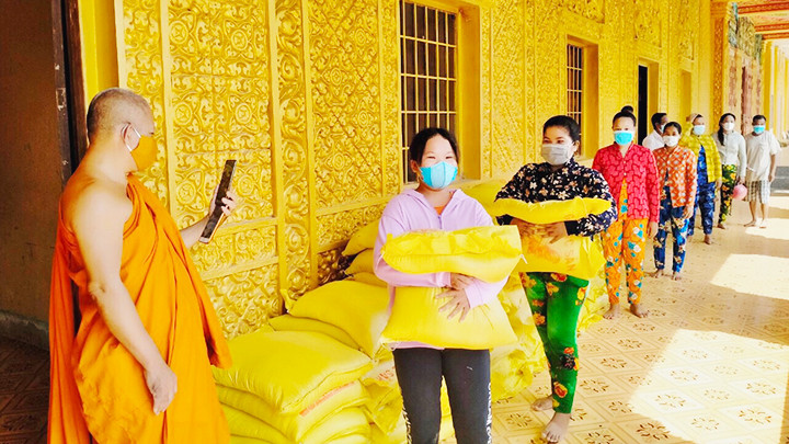 Thượng tọa Tăng Sa Vông vận động và trao gạo, hàng hóa giúp các hộ nghèo khó.