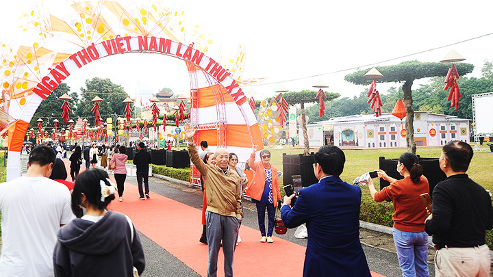 Người dân chụp ảnh lưu niệm bên cổng chào.