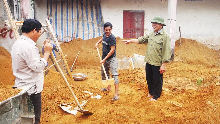 Ông Hồ Sĩ Quảng (ngoài cùng, bên phải) hướng dẫn xã viên làm phân vi sinh cho giá thể mạ.