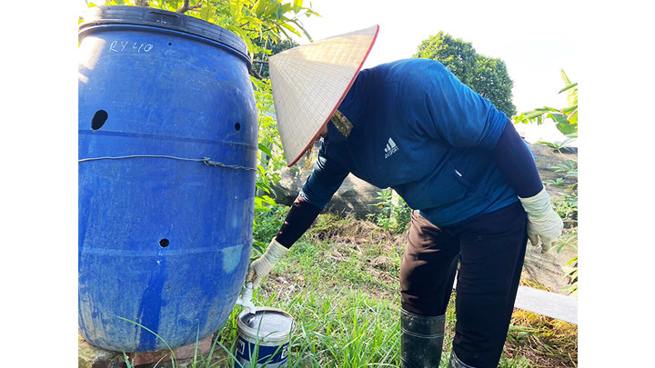 Thu hoạch phân bón hữu cơ từ rác để tưới cây.