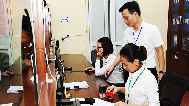 Công chức, viên chức làm việc tại bộ phận một cửa của phường Mộ Lao (Hà Đông). Ảnh: NGUYỆT ANH