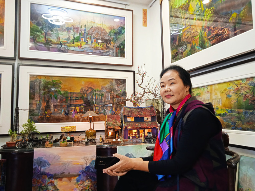 Họa sĩ Thanh Thục bên một số tác phẩm tranh vải.