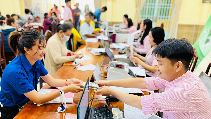 Cán bộ NHCSXH giải ngân nguồn vốn ưu đãi cho các đối tượng chính sách. (Ảnh VIỆT HẢI) 