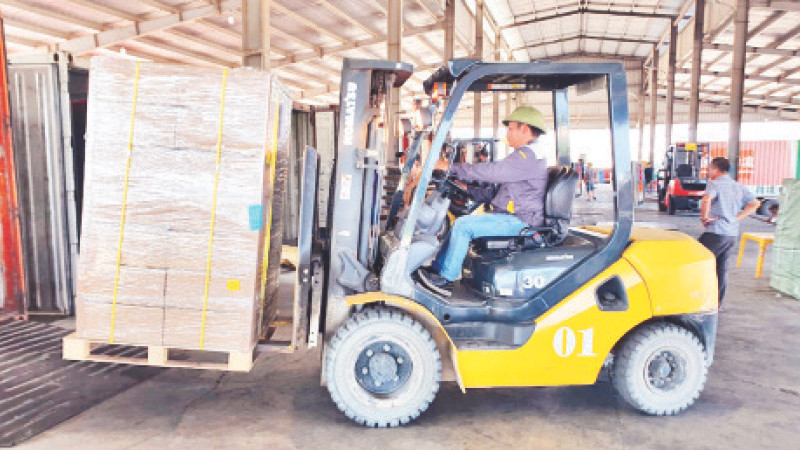 Bốc xếp hàng hóa nhập khẩu tại bãi kiểm hóa cầu Bắc Luân II.