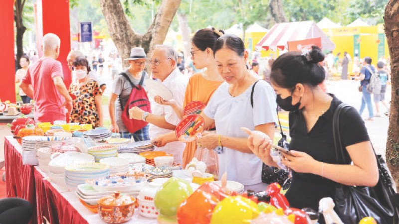 Khách du lịch tìm hiểu sản phẩm tại Lễ hội Quà tặng du lịch Hà Nội mới được tổ chức.