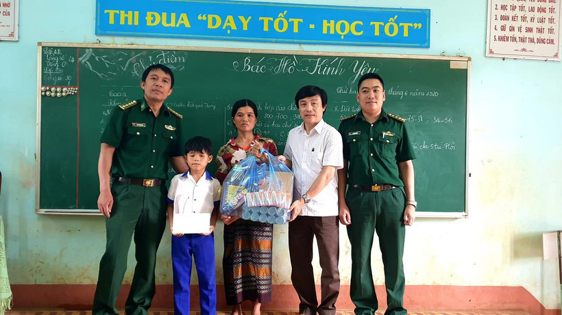 Thầy giáo Trọng và bộ đội biên phòng tặng quà cho gia đình có hoàn cảnh khó khăn.