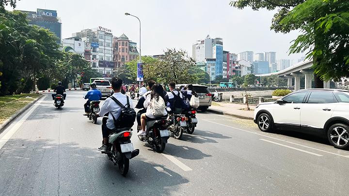 Học sinh không đội mũ bảo hiểm, dàn hàng ngang tham gia giao thông.