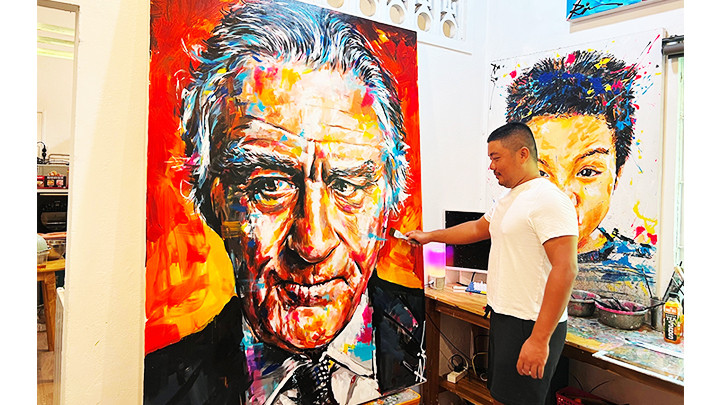 Họa sĩ Rin Art bên một bức tranh đang hoàn thiện.