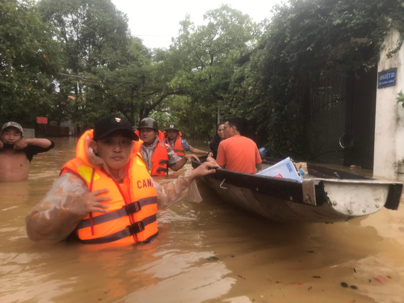 Công an phường An Cựu (thành phố Huế) hỗ trợ người dân di dời khỏi vùng bị ngập nặng sáng 15/10. (Ảnh: CÔNG HẬU)