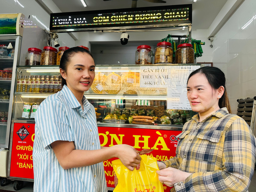Hộ gia đình chị Phạm Tuyết Linh (bên trái), cơ sở sản xuất bánh mì và chả lụa Sơn Hà nổi tiếng hơn 40 năm qua tại Bạc Liêu ký cam kết với cơ quan chức năng thực hiện nghiêm các biện pháp an toàn thực phẩm trong dịp Tết. (Ảnh: TRỌNG DUY)