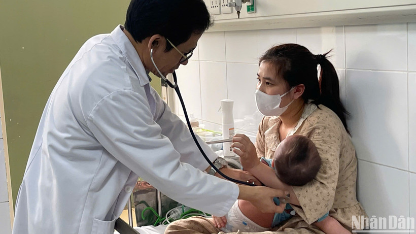 Tiến sĩ, bác sĩ Đỗ Thiện Hải, Phó Giám đốc Trung tâm bệnh Nhiệt đới, Bệnh viện Nhi Trung ương khám cho bệnh nhi mắc sởi. (Ảnh: HẢI NGÔ)