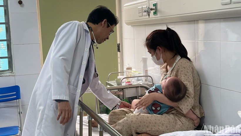 Bác sĩ khám cho bệnh nhi nằm viện do mắc sởi. (Ảnh: HẢI NGÔ)