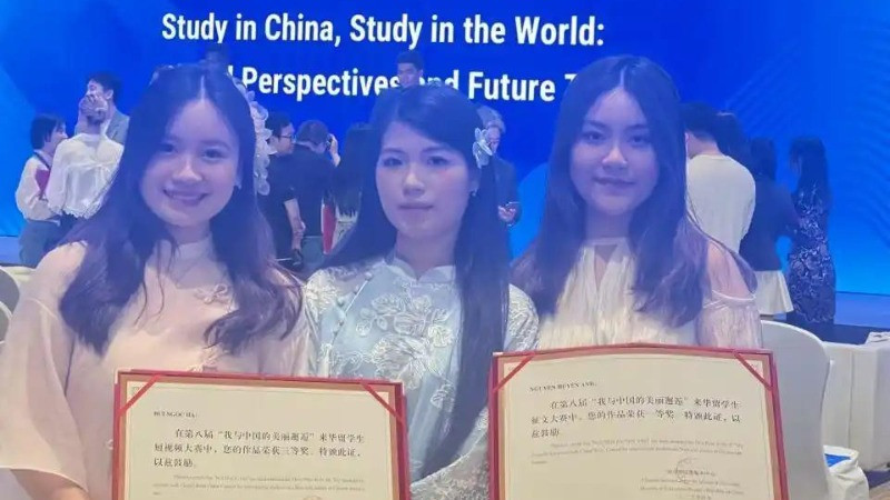Nguyễn Huyền Anh (phải) chụp ảnh tập thể cùng các sinh viên Việt Nam đạt giải tại lễ trao giải