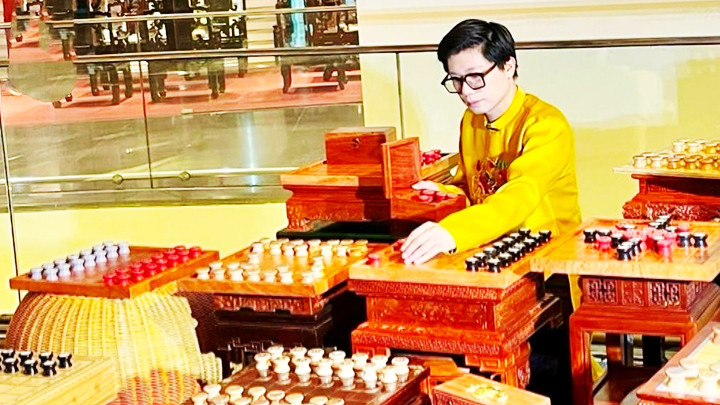 Đạo diễn Ninh Quang Trường bên bộ Cờ Mặt Trời do anh sáng tạo.