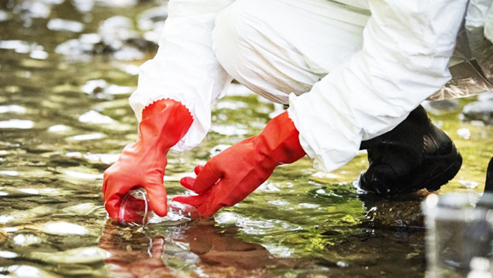 Chuyên gia môi trường thu thập mẫu nước thải gần một cơ sở sản xuất dược phẩm của Đức. Ảnh: MEDWATCH