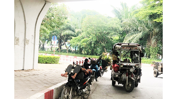 Thời tiết oi nóng khiến nhiều người lao động phải tìm chỗ tránh trú ở gầm cầu và những nơi có cây xanh.