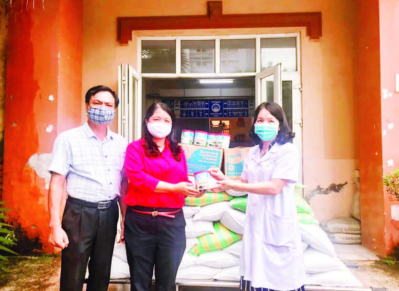 Chị Bùi Thị Lan Phương (đứng giữa) cùng cán bộ Chữ thập đỏ quận Cầu Giấy hỗ trợ lương thực, thực phẩm cho các gia đình khó khăn trong thời gian dịch Covid-19.