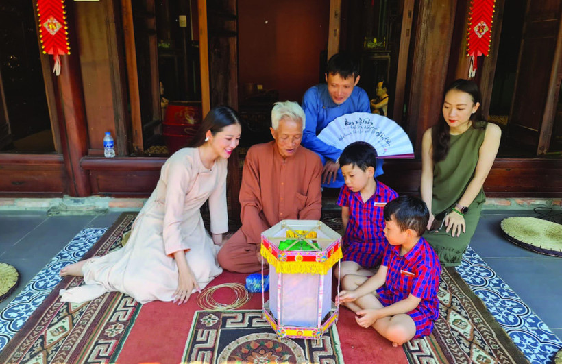 Nghệ nhân Nguyễn Văn Quyền (thứ hai từ trái sang; xã Cao Viên, huyện Thanh Oai, Hà Nội) giới thiệu cách làm đèn kéo quân. 
