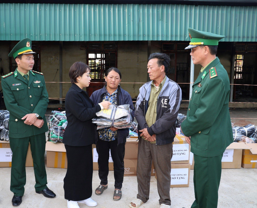 Cán bộ Đồn Biên phòng Nậm Lạnh phối hợp với đoàn thiện nguyện trao quà cho gia đình em học sinh gặp nạn trong vụ cháy.