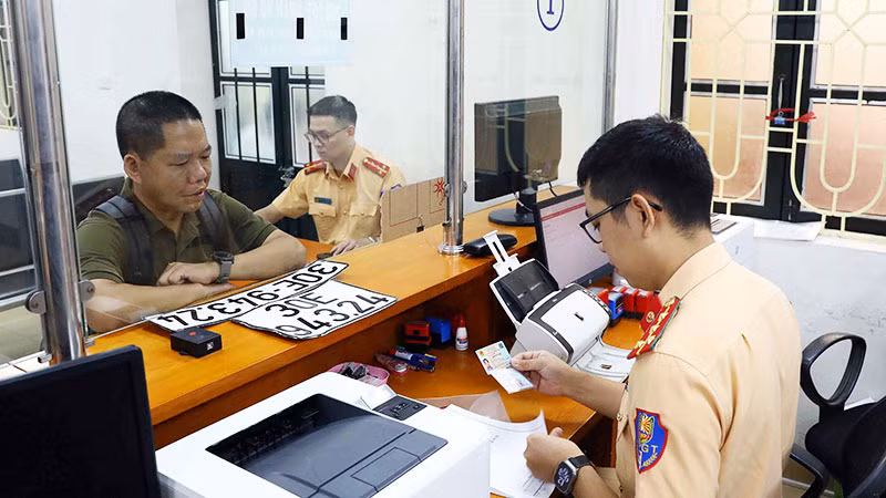 Người dân làm thủ tục thu hồi biển số xe tại cơ sở đăng ký số 1, Phòng Cảnh sát giao thông Công an thành phố Hà Nội. (Ảnh: PHẠM KIÊN)