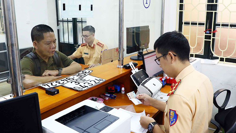 Người dân làm thủ tục thu hồi biển số xe tại cơ sở đăng ký số 1, Phòng Cảnh sát giao thông Công an thành phố Hà Nội. (Ảnh: PHẠM KIÊN)