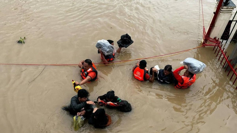 Lực lượng bảo vệ bờ biển Philippines sơ tán người dân sau khi nước lũ dâng cao tại Camarines Sur, Philippines. (Ảnh: Reuters)