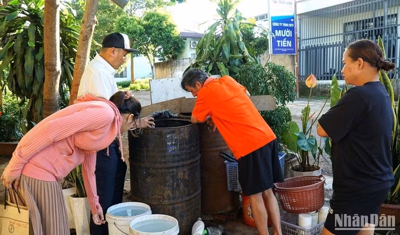 Cán bộ ngành Y tế Đắk Lắk hướng dẫn người dân thị xã Buôn Hồ diệt lăng quăng, bọ gậy phòng chống bệnh viêm não Nhật Bản. (Ảnh: Quang Nhật).