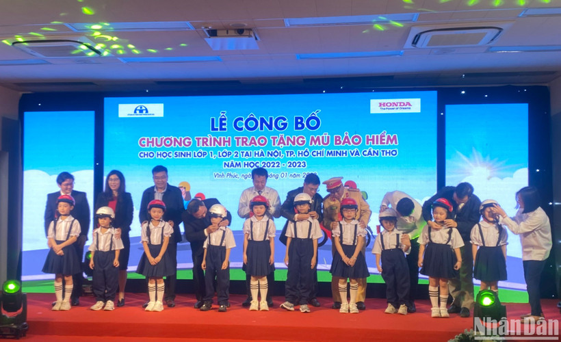 Đại diện ban tổ chức tặng mũ cho các học sinh lớp 1 và lớp 2 tại lễ công bố chương trình.