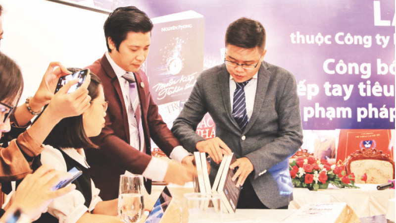 Đại diện First News hướng dẫn cách phân biệt sách giả, sách thật tại một cuộc họp báo.