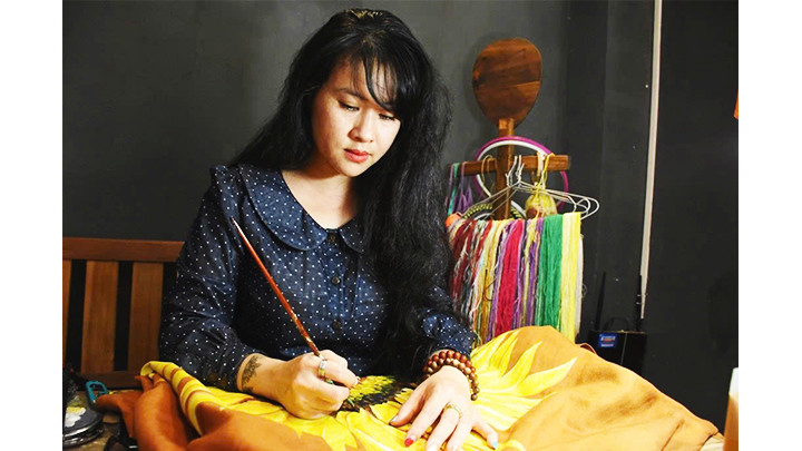 Nhà thiết kế Nguyễn Thị Bảo Quyên vẽ hoa hướng dương lên sản phẩm áo dài.