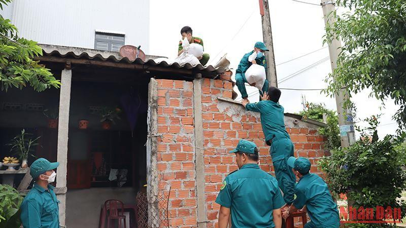 Các lực lượng chức năng giúp người dân thị xã Đức Phổ (Quảng Ngãi) chằng chống nhà cửa.
