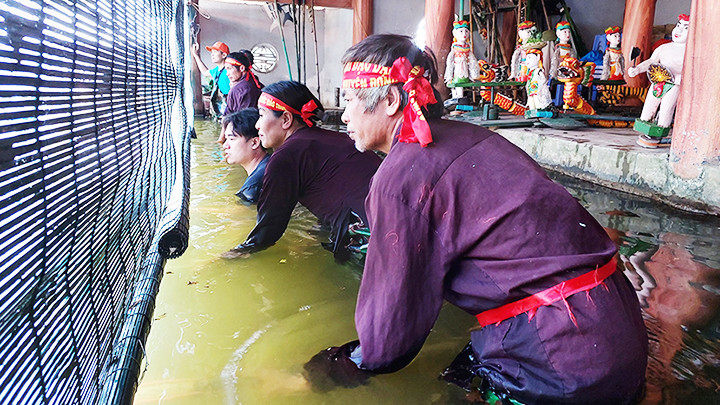 Các nghệ nhân đứng ở bên trong thủy đình điều khiển những con rối.