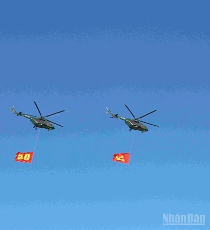 Đội hình máy bay trực thăng mang cờ Đảng, cờ Tổ quốc Lào trên bầu trời quảng trường That Luang. (Ảnh: DUY TOÀN)