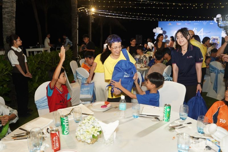 Bà Trần Mai Anh, Trưởng phòng Truyền thông (Ban Truyền thông Vietnam Airlines-áo vàng) trao tặng quà cho các em nhỏ có hoàn cảnh khó khăn. ndo_br_ba-tran-mai-anh-truong-phong-truyen-thong-ban-truyen-thong-vietnam-airlines-trao-tang-qua-cho-cac-em-nho-co-hoan-canh-kho-khan.jpg