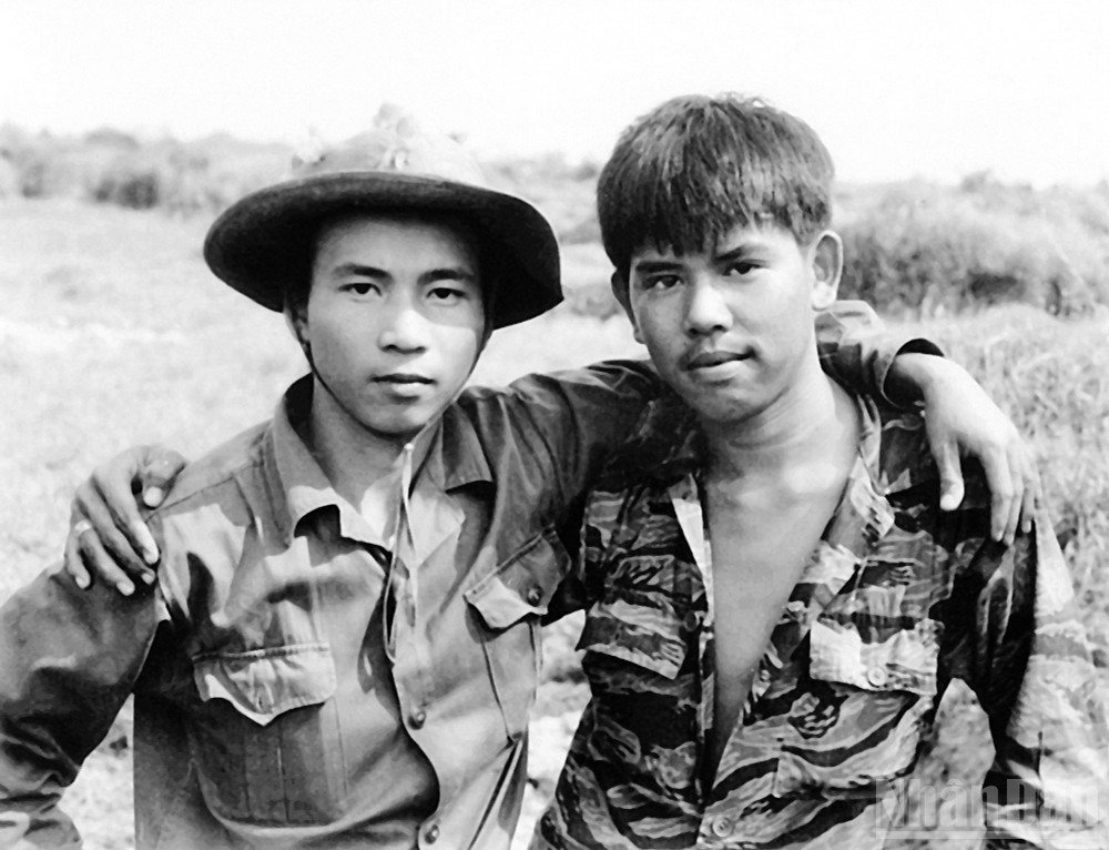 Tác phẩm nhiếp ảnh “Hai người lính” của nghệ sĩ nhiếp ảnh, nhà báo Chu Chí Thành - Giải thưởng Hồ Chí Minh về văn học, nghệ thuật năm 2022. ndo_br_13-hai-nguoi-linh-nguyen-huy-tao-quan-giai-phong-nguoi-ha-noi-va-bui-trong-nghia-linh-cong-hoa-nguoi-sai-gon-khoac-vai-nhau-don-mung-hoa-binh-o-chot-long-quang-1973-chu-chi-thanh.jpg