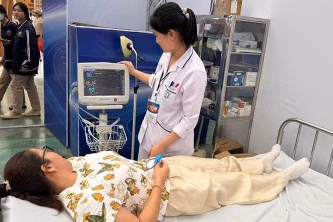 Cán bộ y tế chăm sóc sức khỏe người dân khi tham quan Triển lãm thành tựu đất nước.