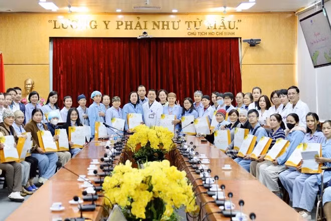 Lãnh đạo Bệnh viện K, các y, bác sĩ chụp ảnh lưu niệm với những người bệnh tại buổi gặp mặt.
