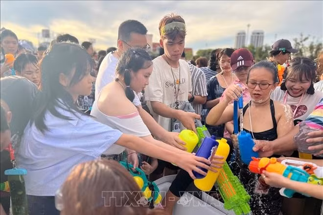 Người tham gia lễ hội chờ lấy nước để té vào nhau - một trong những điểm nổi bật của lễ hội Songkran. (Ảnh tư liệu: Huy Tiến/TTXVN)