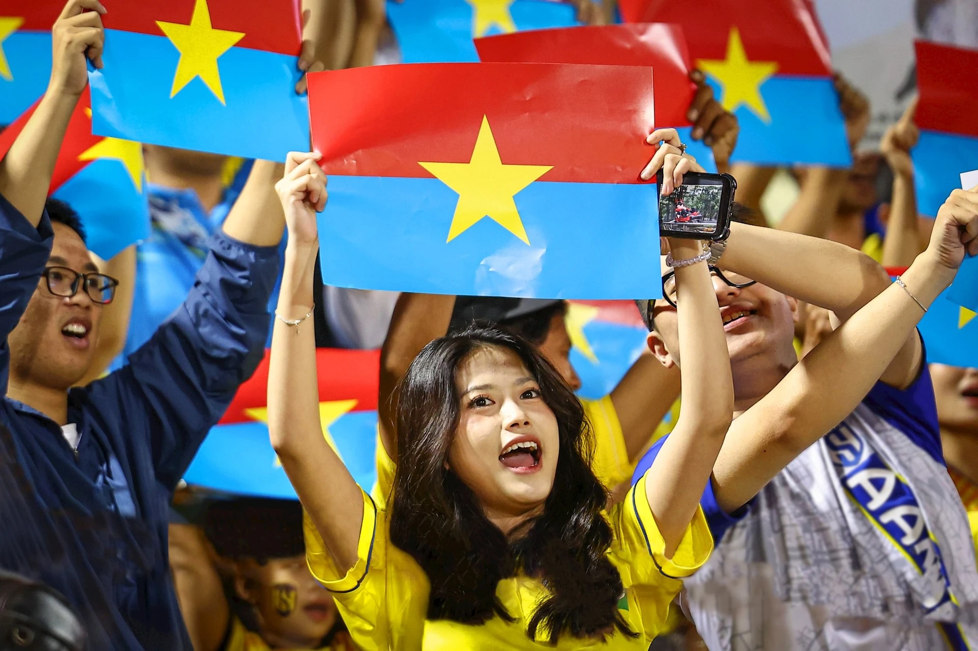 Hàng nghìn cổ động viên của câu lạc bộ bóng đá Sông Lam Nghệ An mang cờ của Mặt trận Dân tộc Giải phóng miền Nam Việt Nam đến sân vận động Thống Nhất (Thành phố Hồ Chí Minh) để chào mừng 50 năm Ngày thống nhất đất nước. Ảnh: Khoa Nguyễn