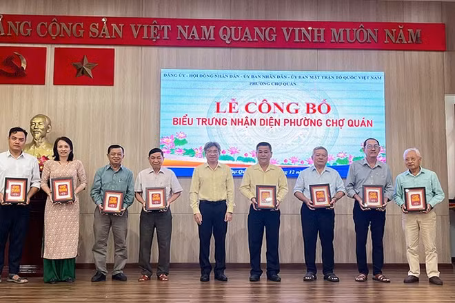 Lãnh đạo phường Chợ Quán tặng bộ ấn phẩm biểu trưng nhận diện phường đến các cơ quan, đơn vị trên địa bàn.