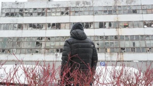 Một người đàn ông đang nhìn hướng về tòa nhà bị phá hủy bởi tên lửa và máy bay không người lái của Nga tại Thủ đô Kiev của Ukraine, ngày 9/1/2026. (Ảnh: Xinhua)