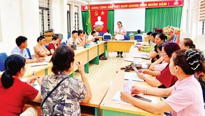 Cán bộ Phòng Giao dịch Ngân hàng Chính sách xã hội Bát Xát phổ biến các chương trình tín dụng chính sách.