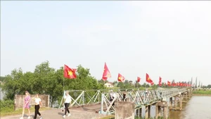Du khách quốc tế tham quan cầu Hiền Lương - sông Bến Hải thuộc Di tích quốc gia đặc biệt Đôi bờ Hiền Lương - Bến Hải, tỉnh Quảng Trị. (Ảnh: TTXVN)