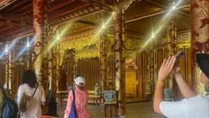 Khách tham quan chiêm ngưỡng Bảo vật quốc gia Ngai vàng triều Nguyễn tại Điện Thái Hòa.